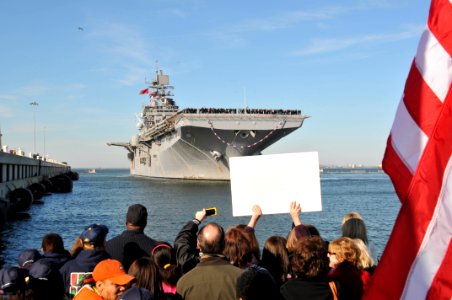 US Navy 120207-N-QY430-064 A crowd cheers as the amphibious assault ship USS Bataan (LHD 5) pulls into Naval Station Norfolk after completing a 10