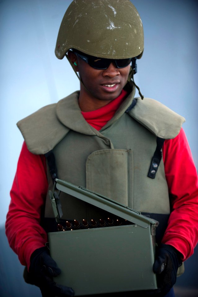 US Navy 120206-N-PB383-745 Aviation Ordnanceman Airman Joshua Poole carries .50-caliber machine gun ammunition during a live-fire exercise aboard t