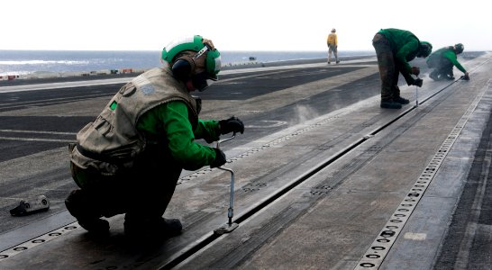 US Navy 120207-N-OY799-007 Aviation Boatswain's Mate (Equipment) Airman Dannielle Byrum removes a button from a catapult on the flight deck of the