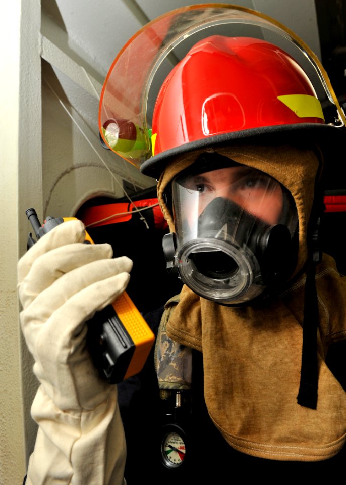 US Navy 120209-N-ZR940-034 Damage Controlman Fireman Dominic Green relays a message during a general quarters exercise in the hangar bay of the Nim