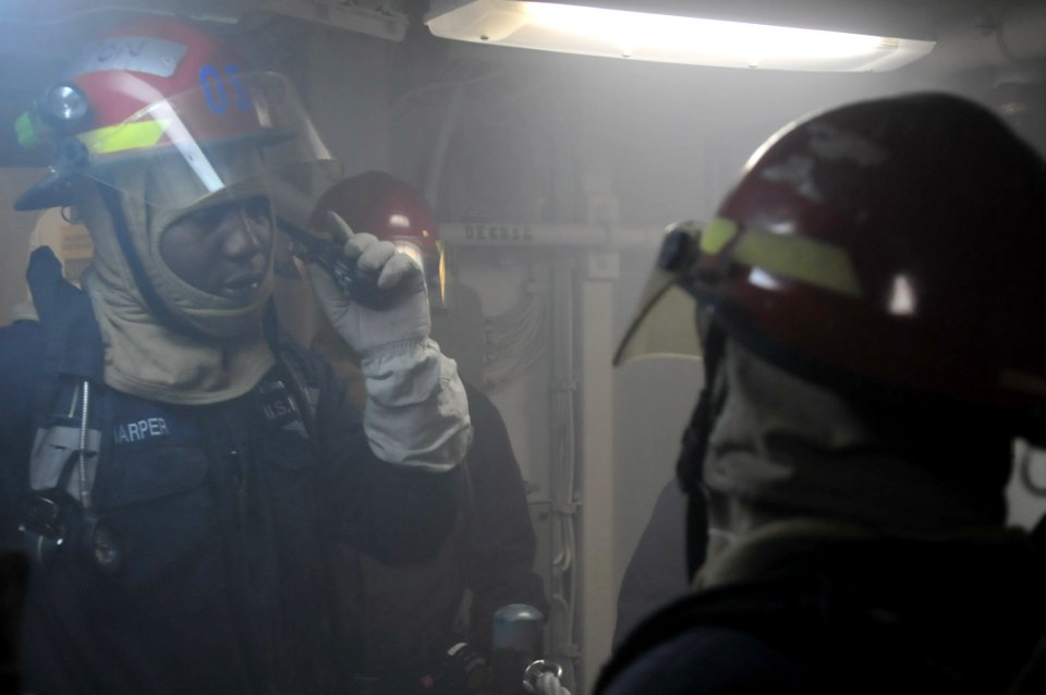 US Navy 120209-N-MU720-170 Engineman 1st Class Dirke Harper receives a message from the damage control training team aboard the mine countermeasur