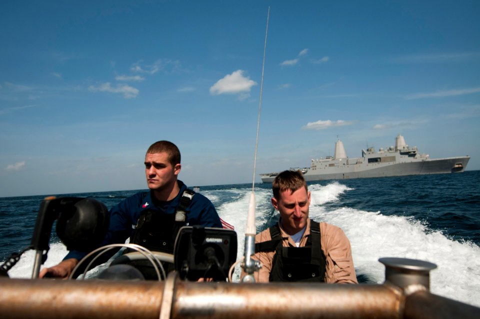 US Navy 120207-N-PB383-126 Boatswain's Mate 1st Class Darren Undercuffler drives a rigid hull inflatable boat away from the amphibious transport do