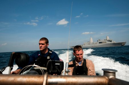US Navy 120207-N-PB383-126 Boatswain's Mate 1st Class Darren Undercuffler drives a rigid hull inflatable boat away from the amphibious transport do