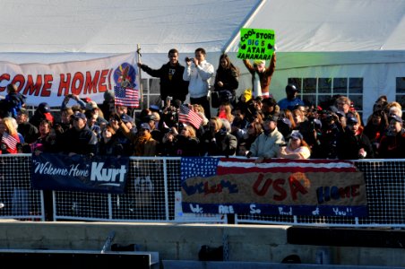 US Navy 120207-N-QY430-058 A crowd cheers as the amphibious assault ship USS Bataan (LHD 5) pulls into Naval Station Norfolk after completing a 10