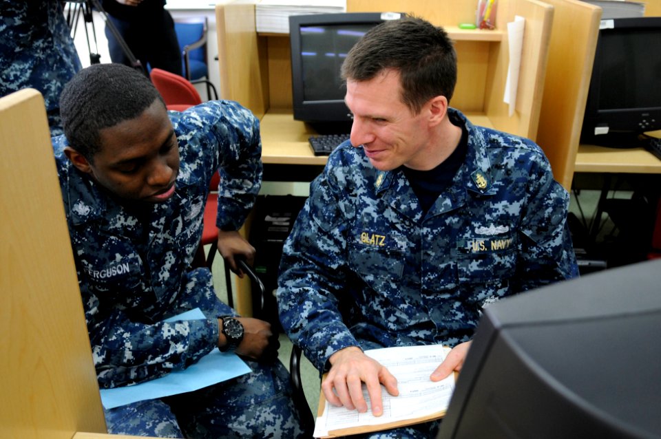 US Navy 120208-N-IO627-025 Chief Fire Controlman Dan Glatz helps Hospital Corpsman 3rd Class Alex Ferguson with his taxes at the Volunteer Income T