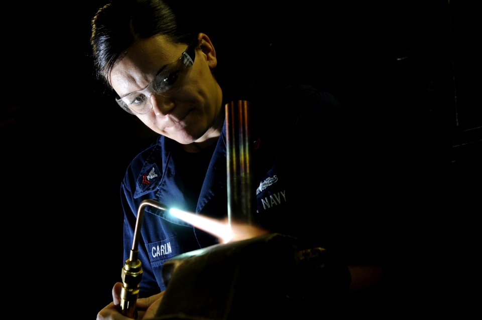 US Navy 120209-N-RG587-230 Hull Maintenance Technician 2nd Class Tiffani Carlin uses an oxy-acetylene torch to separate a pipe from a fitting in th