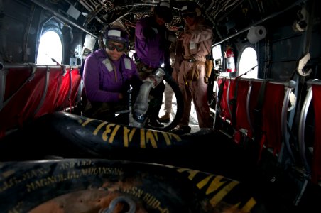 US Navy 120209-N-PB383-157 Aviation Boatswain's Mate (Fuels) Airman Edwin Montanez refills a fuel bag inside a CH-46E Sea Knight helicopter