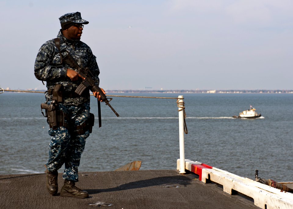 US Navy 120210-N-FI736-038 Aviation Ordnanceman Airman Breon Jones stands watch as the aircraft carrier USS Enterprise (CVN 65) pulls into port