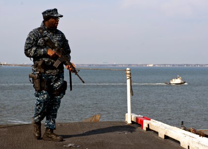US Navy 120210-N-FI736-038 Aviation Ordnanceman Airman Breon Jones stands watch as the aircraft carrier USS Enterprise (CVN 65) pulls into port