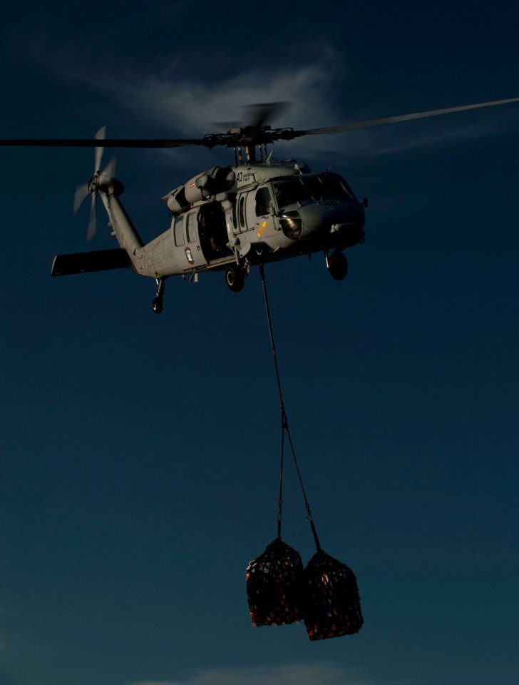 US Navy 120209-N-DR144-055 An MH-60S Sea Hawk helicopter assigned to Helicopter Anti-Submarine Squadron (HSC) 23 delivers supplies to the flight de