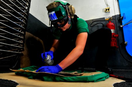 US Navy 120209-N-ZI635-026 Aviation Structural Mechanic Airman Caitlin Vancourt, assigned to Strike Fighter Squadron (VFA) 22, stencils flight deck