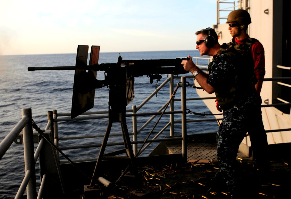 US Navy 120208-N-RG587-132 Cmdr. David Harris, intelligence officer aboard the Nimitz-class aircraft carrier USS Carl Vinson (CVN 70), left, fires