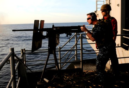 US Navy 120208-N-RG587-132 Cmdr. David Harris, intelligence officer aboard the Nimitz-class aircraft carrier USS Carl Vinson (CVN 70), left, fires