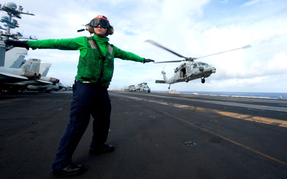 US Navy 120208-N-OY799-356 A Sailor directs an MH-60S Sea Hawk helicopter from the Eightballers of Helicopter Sea Combat Squadron (HSC) 8 to take o