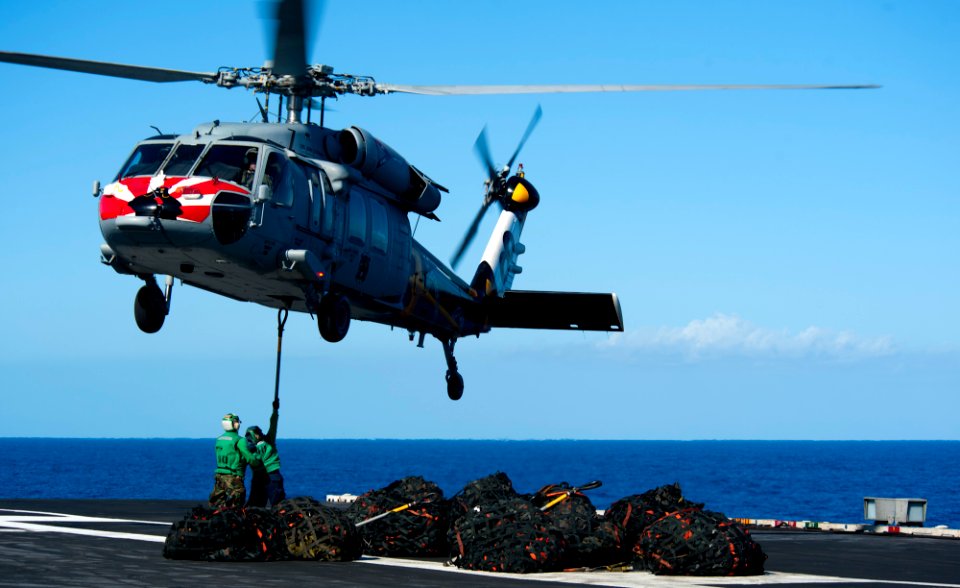 US Navy 120212-N-OY799-517 Logistics Specialist Seamen Cody James and Rachel Foster hook cargo to an MH-60S Sea Hawk helicopter from the Eightballe