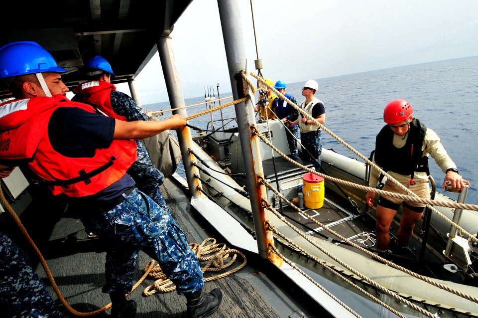US Navy 120211-N-IZ292-077 Seaman James Aguilar steadies a rigid-hull inflatable boat during small boat operations aboard the guided-missile frigat