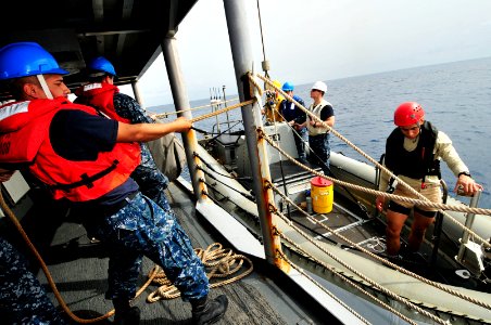 US Navy 120211-N-IZ292-077 Seaman James Aguilar steadies a rigid-hull inflatable boat during small boat operations aboard the guided-missile frigat