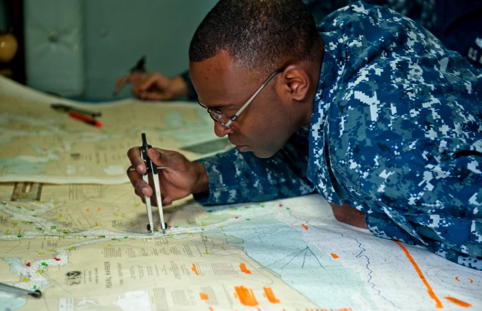 US Navy 120208-N-GC412-006 Quartermaster 3rd Class Clem Benton, one of the ship's chart petty officers, plots the ship's inboard coordinates to Haw