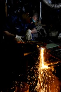 US Navy 120209-N-RG587-206 Hull Maintenance Technician Fireman Stephan Tucker uses an oxy-acetylene torch to cut steel in the metalsmithing shop ab
