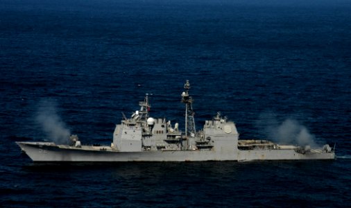 US Navy 120214-N-BC134-031 The guided-missile cruiser USS Bunker Hill (CG 52) fires two MK-45 5 inch-54-caliber lightweight guns simultaneously