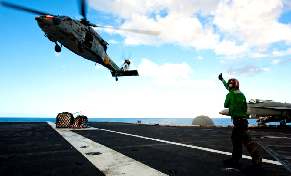 US Navy 120212-N-OY799-114 A Sailor directs an MH-60S Sea Hawk helicopter from the Eightballers of Helicopter Sea Combat Squadron (HSC) 8 during a