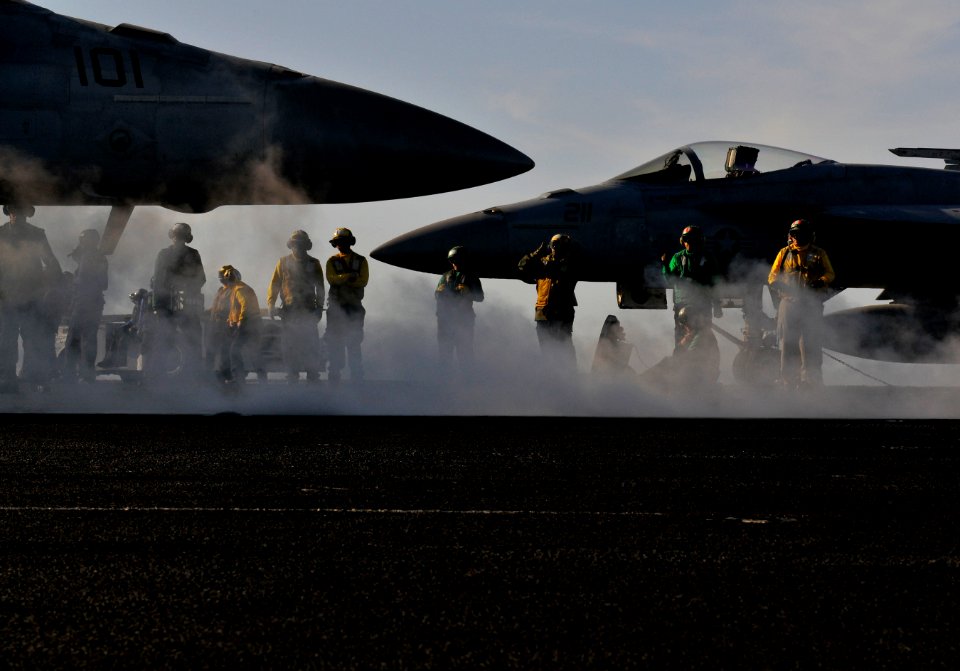 US Navy 120208-N-ZI635-168 An aircraft director guides an F-A-18F Super Hornet into position for launch from the bow catapults aboard the Nimitz-cl