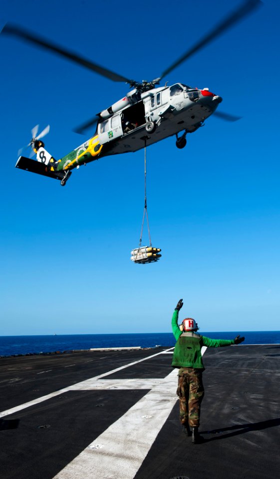 US Navy 120212-N-OY799-418 A Sailor directs an MH-60S Sea Hawk helicopter from the Eightballers of Helicopter Sea Combat Squadron (HSC) 8 during a
