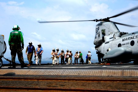 US Navy 120212-N-WV964-152 Mock non-combatant evacuation operation (NEO) participants exit a CH-46 Sea Knight helicopter aboard the forward-deploye photo