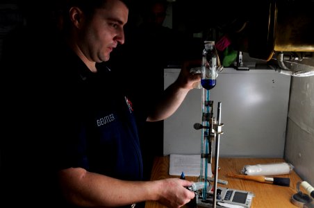 US Navy 120210-N-RG587-052 Sailors uses a titration rig to measure volumes of liquid while testing water chloride levels in the reactor labs office