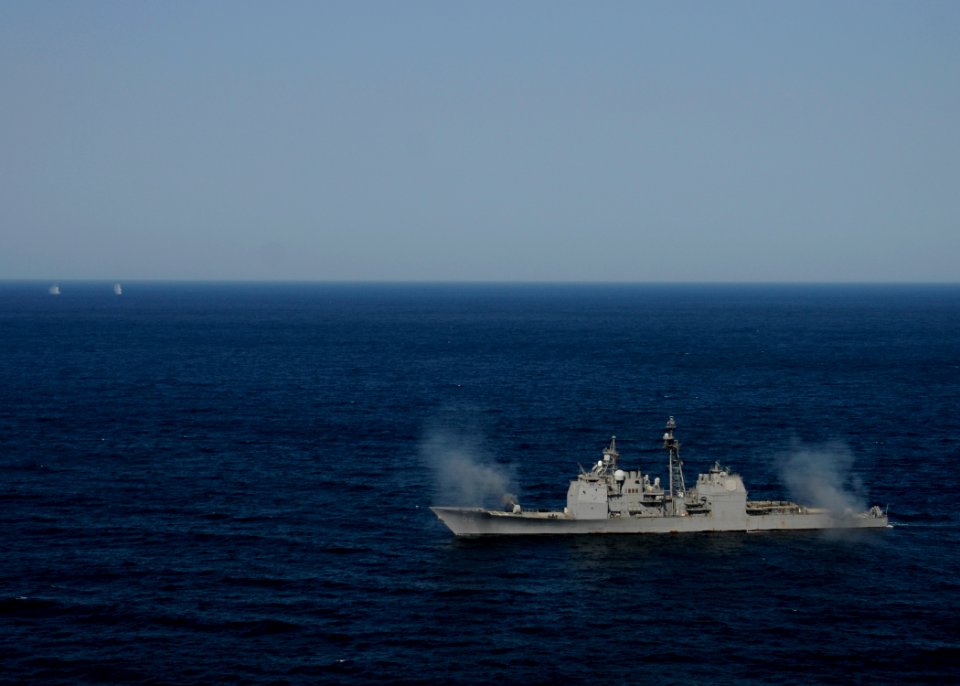 US Navy 120214-N-BC134-068 The guided-missile cruiser USS Bunker Hill (CG 52) fires two MK-45 5 inch-54-caliber lightweight guns simultaneously