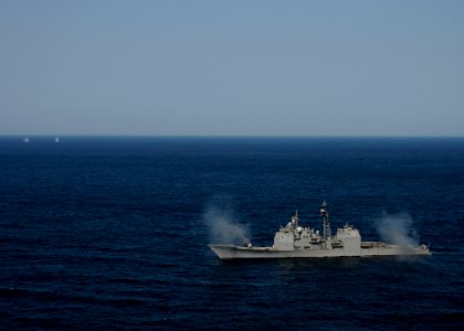 US Navy 120214-N-BC134-068 The guided-missile cruiser USS Bunker Hill (CG 52) fires two MK-45 5 inch-54-caliber lightweight guns simultaneously