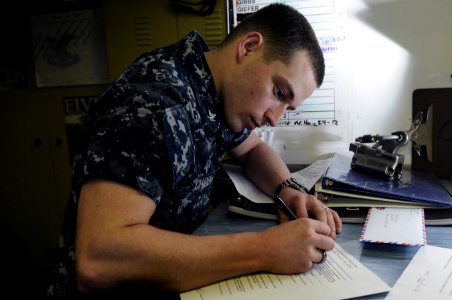 US Navy 120215-N-RG587-033 Electronics Technician 3rd Class Marley Camden fills out a safety harness check out form in electrical tool issue
