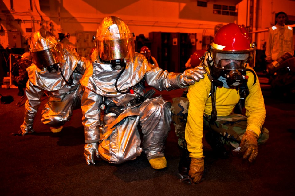 US Navy 120214-N-BT887-158 Sailors brace for shock during a general quarters training exercise aboard the Nimitz-class aircraft carrier USS John C