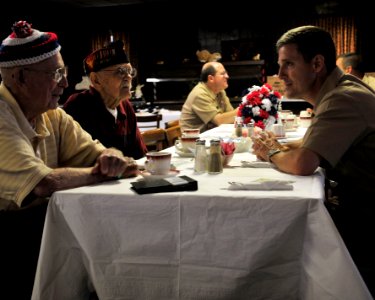 US Navy Commanding Officer of the multipurpose amphibious assault ship USS Bataan (LHD 5) Capt. Steve Koehler, talks with Bataan Death March survivors James Downey Jr. and Marion photo