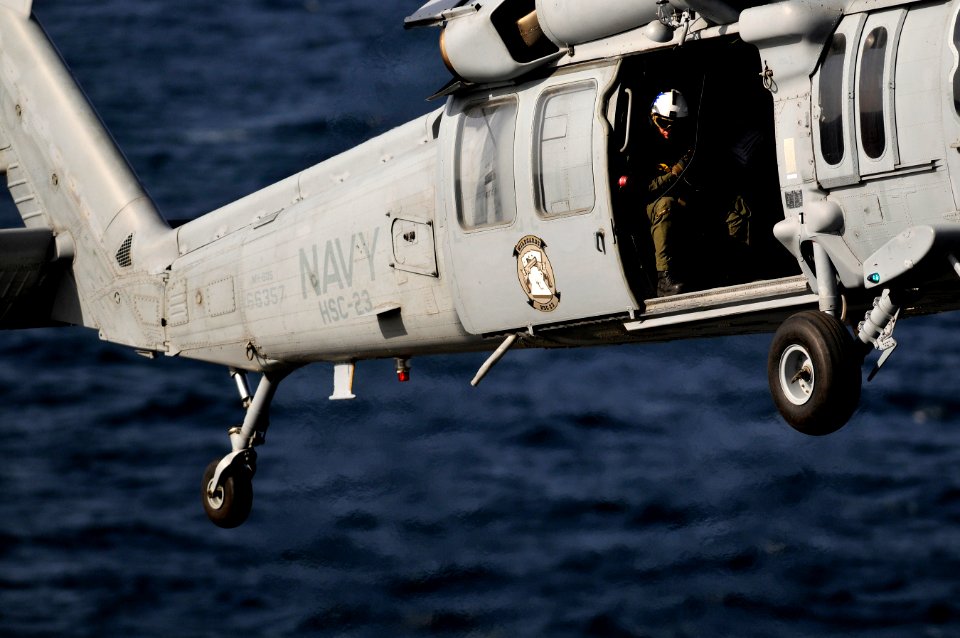US Navy 120214-N-UT411-230 A Naval air crewman assigned to Helicopter Sea Combat Squadron (HSC) 23 guides the pilots of an MH-60S Sea Hawk helicopt