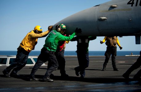 US Navy 120215-N-DR144-429 Sailors perform an aircraft pushback to position an F-A-18C Hornet on the flight deck of the Nimitz-class aircraft carri