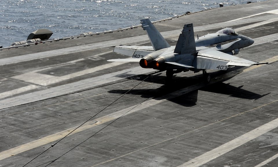 US Navy 120216-N-VO377-432 An F-A-18C Hornet assigned to the Blue Blasters of Strike Fighter Squadron (VFA) 34 traps the arresting wire on the flig