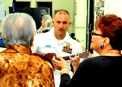 US Navy Lt. Cmdr. Mike Foskett plays the ukulele as local elderly women sing the Chamorro song during a community service project at the Yona-Talofofo Senior Citizens Center in Talofofo