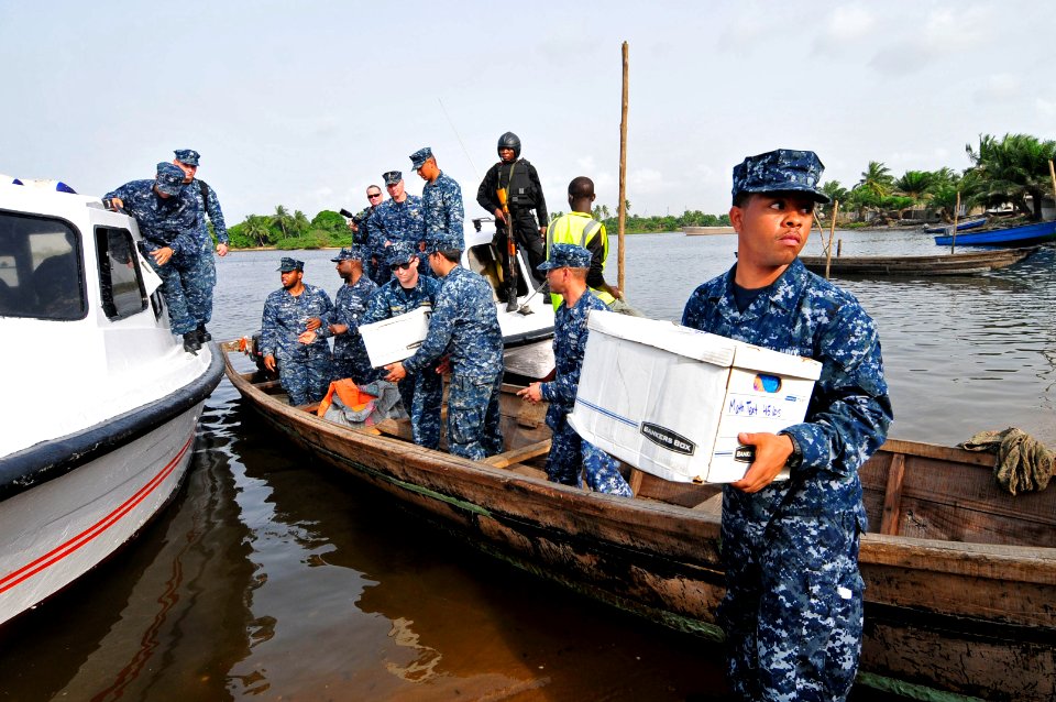 US Navy 120216-N-IZ292-005 Ship's Serviceman Seaman Recruit Bernard Ford, right, assigned to the guided-missile frigate USS Simpson (FFG 56), helps