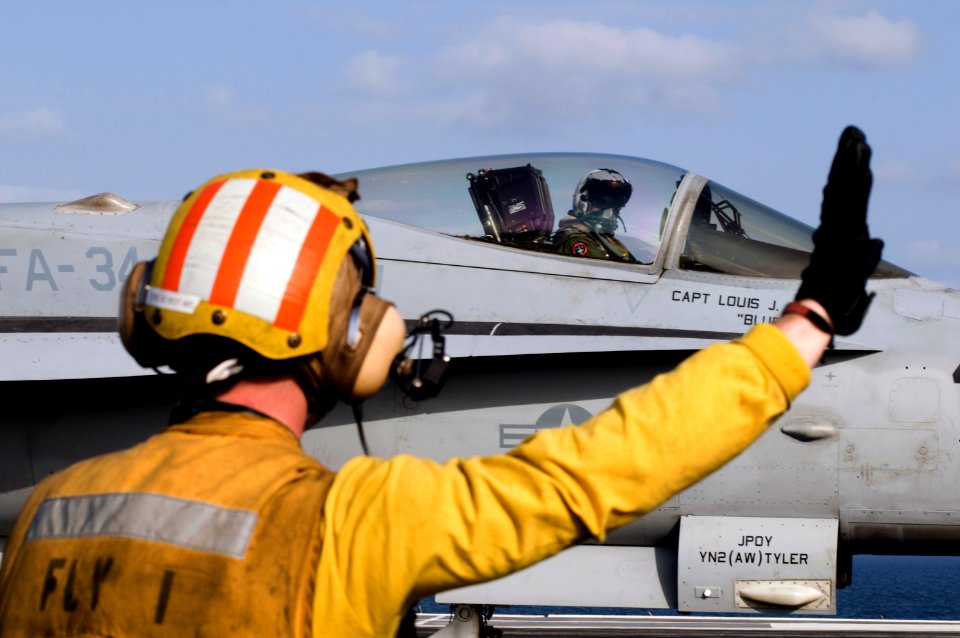 US Navy 120216-N-JN664-090 A Sailor directs the pilot of an F-A-18C Hornet assigned to the Blue Blasters of Strike Fighter Squadron (VFA) 34 on the