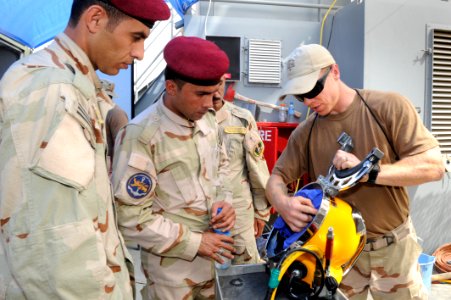 US Navy Diver Ryan Oakley explains the inner workings of a Kirby Morgan 37 diving helmet to Iraqi sailors