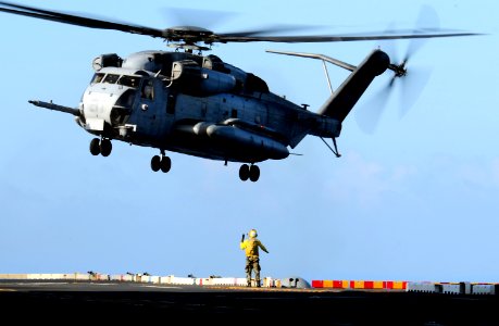 US Navy http-www.navy.mil-management-photodb-photos-100601-N-7948R-305 A Sailor guides a CH-53E Sea Stallion during flight operations aboard the amphibious assault ship USS Peleliu (LHA 5)