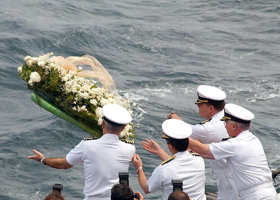 US Navy members toss a wreath into the sea during a memorial ceremony commemorating the one-year anniversary of the 911 terrorist attacks