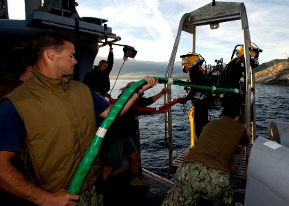 US Navy Divers, alongside the Joint POW-MIA Accounting Command, search for an unaccounted-for service member who went missing during World War II 121018-N-OT964-052