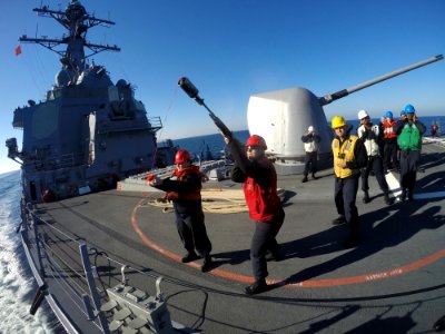 USS Carney (DDG-64) Gunner's Mate firing shot line during underway replenishment 160202-N-FP878-339