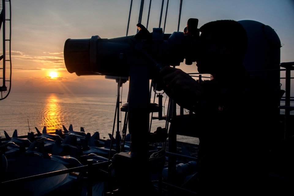 USS George Washington sailor uses binoculars 131026-N-IP531-036