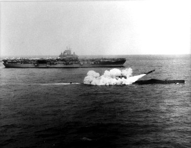 USS Halibut (SSGN-587) firing a Regulus missile next to USS Lexington (CV-16), 25 March 1960