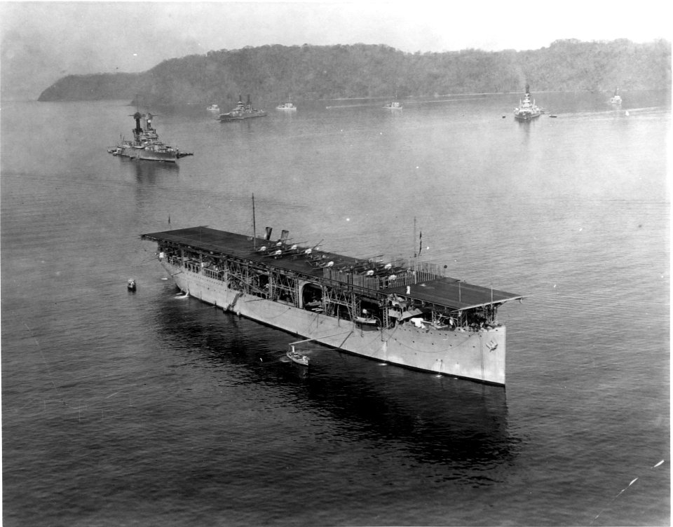 USS Langley (CV-1) at anchor with battleships, in 1923 (NNAM.1996.488.010.006)