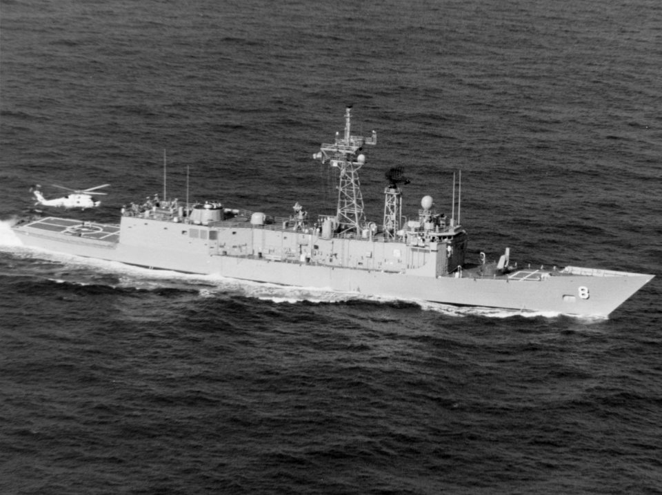 USS McInerney (FFG-8) underway at sea, with a SH-60B Seahawk over her landing area, circa the 1990s (NH 107574-KN)