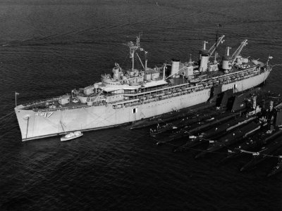 USS Nereus (AS-17) at anchor with submarines alongside, circa in February 1959 (NH 107763)